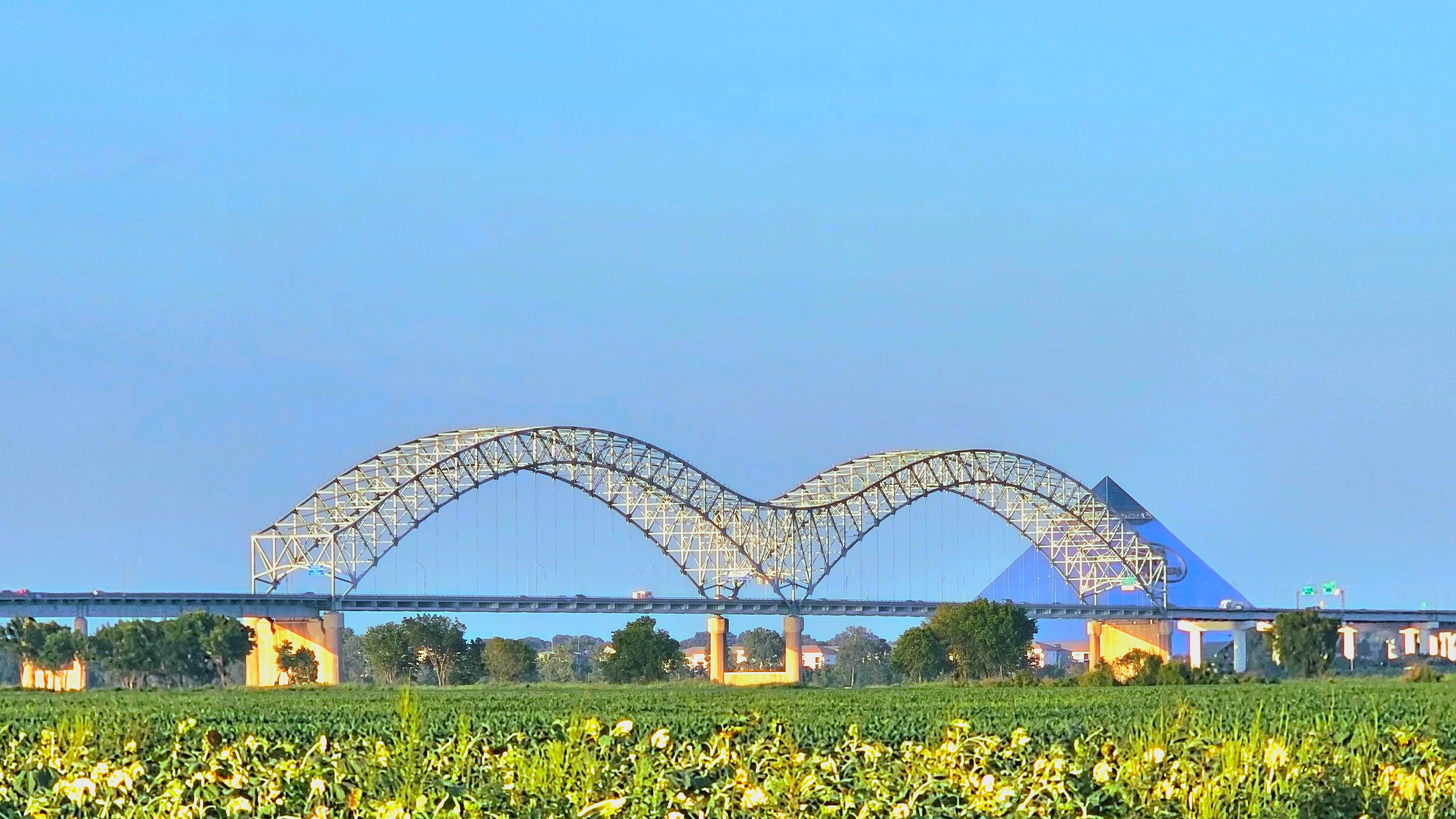 A photo capture of Hernando Desoto bridge and Pyramid, in Memphis, Tennessee, USA, from a distant field.